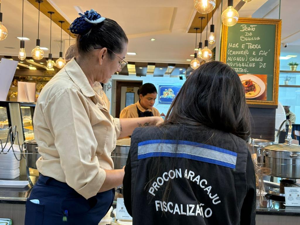 Dois servidores do Procon Aracaju fiscalizando um estabelecimento